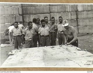 1944-01-26. AUSTRALIAN AND NEW GUINEA ADMINISTRATION UNIT NATIVES WATCHING A JEEP CHASSIS BEING UNPACKED AT THE FACTORY OF THE FORD MOTOR COMPANY