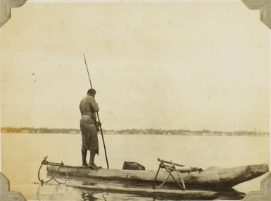 Man standing in a canoe, fishing, 1928