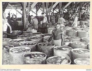 LAE AREA, NEW GUINEA. 1945-07-12. THE DRUM FILLING PLANT AT 2 BULK PETROLEUM STORAGE COMPANY. THE DISTRIBUTION TO LOCAL UNITS IS CARRIED OUT BY 55 BULK ISSUE PETROL AND OIL DEPOT PLATOON