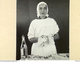 HELDSBACH MISSION FINSCHHAFEN AREA, NEW GUINEA. 1944-03-13. VFX111205 SISTER J. SUTCLIFFE OF THE AUSTRALIAN ARMY NURSING SERVICE CLEANING INSTRUMENTS IN THE OPERATING THEATRE AT THE 2/3RD CASUALTY ..