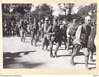 TOROKINA, BOUGAINVILLE. 1945-09-23. JAPANESE NAVAL TROOPS CARRYING PERSONAL GEAR ON A 10-MILE MARCH FROM THE BUKA AREA ESCORTED BY TROOPS OF 27 INFANTRY BATTALION. THE JAPANESE WERE HANDED OVER TO ..