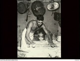 PORT MORESBY, PAPUA. C. 1942-12. AIRCRAFTMAN 1 L. V. HALL OF GEELONG, VIC, IS ROLLING OUT DOUGH SO THAT EVEN IN THE JUNGLE THE RAAF BOYS CAN ENJOY THEIR HOME-MADE MINCE PIES FOR CHRISTMAS
