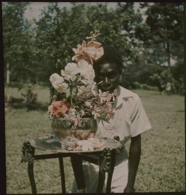 Man standing behind a bowl of flowers in a garden, New Guinea, ca. 1935 / Sarah Chinnery
