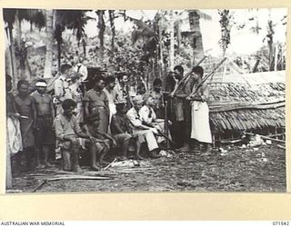 SINGORKAI, NEW GUINEA. 1944-03-19. TWO MEMBERS OF THE PAPUAN INFANTRY BATTALION STANDING GUARD OUTSIDE A PRISON BUILT FOR PRISONERS OF WAR