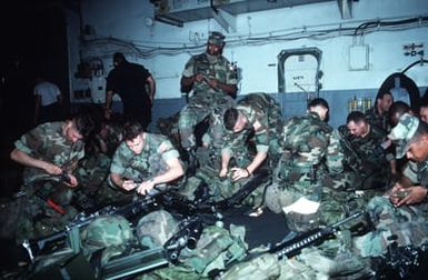 Marines on the hangar deck of the amphibious assault ship USS SAIPAN (LHA-2) fill their magazines with ammunition before boarding helicopters for transportation to Monrovia, Liberia, to evacuate dependents and non-essential U.S. Embassy staff from the midst of fighting between Liberian government forces and rebel factions