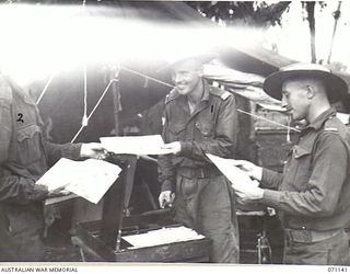 MASAWENG RIVER, NEW GUINEA, 1944-03-12. "THE PREMATURE BURST", A DAILY NEWSPAPER BEING PRODUCED, USING ONLY TYPEWRITER AND DUPLICATOR, BY ARTILLERYMEN OF THE 2/14TH FIELD REGIMENT, WHILE RESTING IN ..