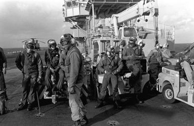 A view of several crewmen on the flight deck of the amphibious assault ship USS GUAM (LPH 9), during operations off the coast of Beirut, Lebanon