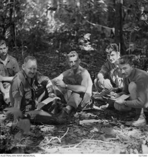 PAPUA, NEW GUINEA. 1942-10. THE COMMANDING OFFICER OF THE 2/31ST AUSTRALIAN INFANTRY BATTALION, AND SOME OF HIS OFFICERS AT A STOPOVER IN DENSE JUNGLE COUNTRY NEAR MENARI. LEFT TO RIGHT:- ..