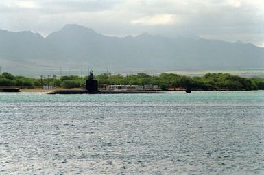 The nuclear-powered attack submarine USS BIRMINGHAM (SSN-695) steams through the channel as it departs from the naval station after a visit.