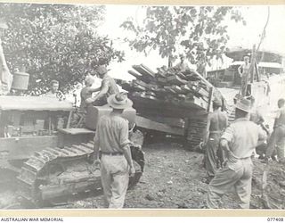 CAPE CUNNINGHAM, NEW BRITAIN. 1944-11-29. SAWN TIMBER BEING LOADED ABOARD A LANDING BARGE BY PERSONNEL OF THE 2/2ND FORESTRY UNIT