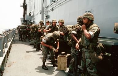 Marines of the 22nd Marine Expeditionary Unit (22nd MEU) stand by to board a helicopter aboard the amphibious assault ship USS SAIPAN (LHA 2) during Operation Sharp Edge. The Marines will be flown to the U.S. Embassy in Monrovia, Liberia, to augment security and evacuate U.S. and foreign nationals from the fighting between government and rebel forces