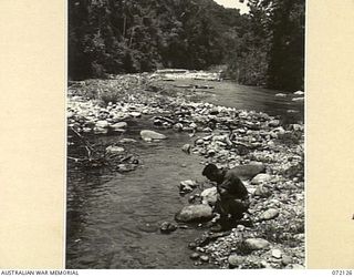 FINSCHHAFEN AREA, NEW GUINEA. 1944-04-09. QX44130 CAPTAIN J.L. GROOM, COMMANDING OFFICER 15TH MALARIA CONTROL UNIT, AT THE JUNCTION OF A TRIBUTARY TO THE SONG RIVER. LIGHT BREEDING OF THE MALARIA ..