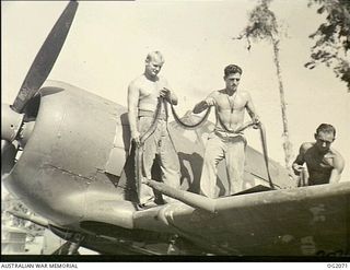 BOUGAINVILLE ISLAND, SOLOMON ISLANDS. 1945-01-17. LEADING AIRCRAFTMAN (LAC) T. F. CRAWFORD, MUNGALLALA, QLD, LAC R. J. BRODERICK, RESERVOIR, VIC, AND CORPORAL J. R. LISTER, MAREEBA, QLD, LOADING ..