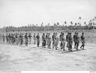 RAPOPO AIRSTRIP, NEW BRITAIN. 1945-09-28. AUSTRALIAN TANK CREWS OF 2/4 ARMOURED REGIMENT MARCH ON TO THE AIRSTRIP TO TAKE OVER TANKS SURRENDERED BY THE JAPANESE. A TOTAL OF OVER 40 JAPANESE MEDIUM ..