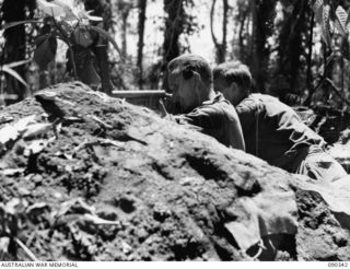 BOUGAINVILLE. 1945-04-05. PTE M.C. DOBBIN (1), AND CPL H.T. ROWE (2), FIRING FROM THEIR WEAPON PIT AT JAPANESE ATTEMPTING TO DIG IN AFTER AN UNSUCCESSFUL COUNTER ATTACK AGAINST BATTALION HQ AND B ..