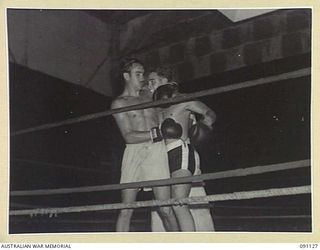 BOSLEY FIELD, TOROKINA, BOUGAINVILLE. 1945-04-21. A. BURKE (1), AND B. NEWMAN (2), DURING THE SECOND OF A SERIES OF INTERNATIONAL BOXING TOURNAMENTS ORGANISED BY OFFICIALS FROM DEPUTY ASSISTANT ..