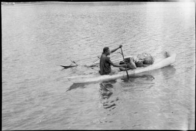 Woman paddling a laden outrigger canoe, Rabaul, New Guinea, ca. 1929 / Sarah Chinnery