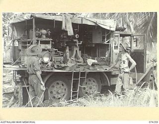 HANSA BAY, NEW GUINEA. 1944-06-22. NX143563 SAPPER SAPRUMPF (1) AND NX85808 SAPPER FOGARTY (2), 8TH AUSTRALIAN FIELD COMPANY, 8TH INFANTRY BRIGADE, INSPECTING A JAPANESE MOBILE WORKSHOP WHICH THE ..