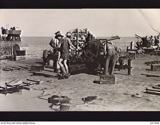 FINSCHHAFEN, NEW GUINEA. 1943-09-22. TROOPS OF THE 2/4TH AUSTRALIAN LIGHT ANTI-AIRCRAFT REGIMENT, FINSCHHAFEN FORCE, PREPARING A 40MM BOFORS GUN FOR ACTION ON THE DECK OF AN LST (LANDING SHIP, ..