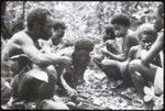 Men and boys eat blood pudding in shrine