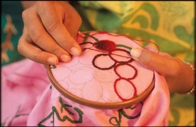 Woman embroidering for a tivaevae