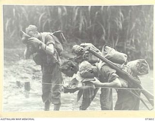 GABEI RIVER, NEW GUINEA. 1944-05-27. MEMBERS OF THE 35TH INFANTRY BATTALION PAUSE TO DRINK FROM THEIR HATS DURING THEIR ADVANCE ALONG THE COAST TOWARDS WEWAK. IDENTIFIED PERSONNEL ARE:- NX142058 ..