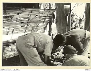 BOUGAINVILLE ISLAND. 1944-12-31. Q22061 SERGEANT O.W. WREN, 25TH INFANTRY BATTALION WHO WAS WOUNDED DURING THE AUSTRALIAN ATTACK ON JAPANESE POSITIONS IN THE PIATERAPAIA SECTOR, RECEIVING A BLOOD ..