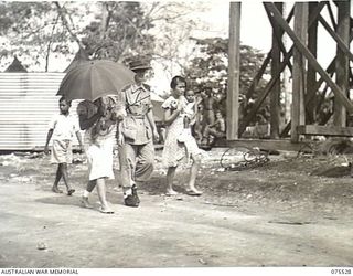 MADANG, NEW GUINEA. 1944-08-25. QFX50502 SISTER M. NEWTON (1) OUT WALKING WITH A CHINESE FAMILY IN THE GROUNDS OF THE 2/11TH GENERAL HOSPITAL. THIS FAMILY WAS CAPTURED BY THE JAPANESE AT MADANG AND ..