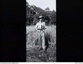 SOPUTA, NEW GUINEA. 1942-03-01. ONE OF THE AIF GUARDS WHO PROTECTED MEMBERS OF THE AUSTRALIAN NEW GUINEA ADMINISTRATIVE UNIT (ANGAU) AS THEY CUT THE LONG KUNAI GRASS TO MAKE AN AIRSTRIP. THE STRIP ..