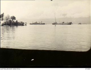Milne Bay, New Guinea. 1944-04-06. A photograph taken through a port hole of the salvaged Motor Vessel Anshun showing allied shipping at anchor in the Bay