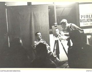PORT MORESBY, PAPUA, NEW GUINEA, 1944-02-02. VX93433 CAPTAIN W. A. DARGIE (1), OFFICIAL WAR ARTIST, MILITARY HISTORY SECTION, LECTURING AND DEMONSTRATING PORTRAIT PAINTING USING QX27970 SERGEANT W. ..