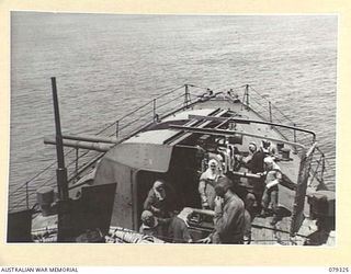 BUT AREA, NEW GUINEA. 1945-02-26. THE CREW OF THE 4" TWIN GUNS OF THE RAN VESSEL HMAS SWAN LOADING UP IN PREPARATION FOR LAYING DOWN ANOTHER BARRAGE ON THE JAPANESE POSITIONS IN THE BUT- KUAK AREA ..