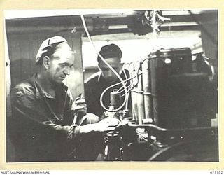 LABU POINT, LAE, NEW GUINEA. 1944-03-24. NX65799 CORPORAL P. A. ROGAN (1), INSTALLING A L 2 GARDENER 38 - 40 HORSE POWER DIESEL ENGINE IN ARMY TRAWLER AS29 AT THE 1ST WATERCRAFT WORKSHOP