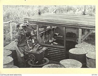 LAE, NEW GUINEA, 1944-03-26. NX104964 GUNNER H. J. AKERS, A GUNNER OF THE 73RD MOBILE SEARCHLIGHT BATTERY, STATION 3, OPERATING A DIRECTOR ELECTRIC CONTROL PILLAR