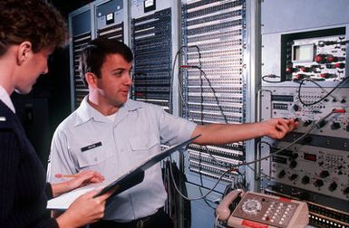 First LT. Christine Geiser and STAFF SGT. Jeff Trotter check for radio distortions at the master net control station of Commando Escort. Commando Escort, part of the 1957th Information Systems Group, links the commnader-in-chief Pacific Command and the commander-in-chief Pacific Air Forces, with bases and military forces throughout the area