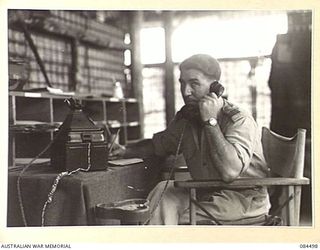 LAE AREA, NEW GUINEA. 1944-12-20. SENIOR REPRESENTATIVE GREEN, YMCA, AT HIS DESK