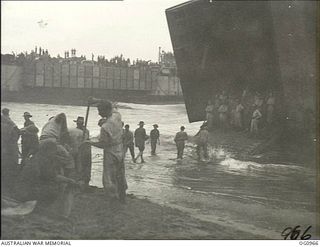 AITAPE AREA, NORTH EAST NEW GUINEA. C. 1944-04-22. RAAF GROUND CREWS CARRY STORES ASHORE FROM A LANDING SHIP, TANK (LST)