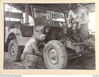 PALMALMAL PLANTATION, JACQUINOT BAY, NEW BRITAIN, 1945-06-06. CRAFTSMAN K. COULTON (1) AND CRAFTSMAN G. DEVINE (2), 1 INFANTRY TROOPS WORKSHOP AT WORK ON THE 'WILLOW RUN' AN ASSEMBLY LINE WHERE OLD ..