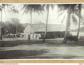 TERAPO, NEW GUINEA, 1943-09-16. VIEW OF THE WATERFRONT, SHOWING THE AUSTRALIAN ARMY SERVICE CORPS STORE (CENTRE FOREGROUND) WITH THE TRAWLER AS30 DISCHARGING CARGO AT THE WHARF