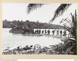 CUTARP PLANTATION, JACQUINOT BAY, NEW BRITAIN. 1944-12-15. TROOPS OF B COMPANY, 19TH INFANTRY BATTALION, LANDING ASHORE AT NAIL'S JETTY FROM LCM808, A US ARMY LANDING CRAFT, MECHANISED BARGE