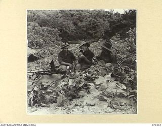 SIO MISSION, NEW GUINEA, 1944-02. NX20609 PRIVATE A.G. DENNIS (1) AND VX106827 PRIVATE L.A. LOWRIE (2), MEMBERS OF THE 2/17TH INFANTRY BATTALION, PICTURED CHATTING WITH VX47864 CHAPLAIN W.L. BYRNE ..