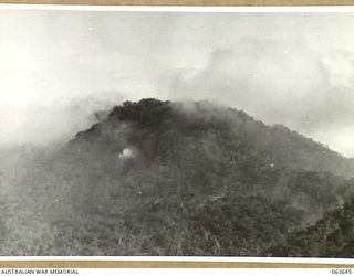 FARIA RIVER, NEW GUINEA. 1944-01-20. SMOKE RISING FROM JAPANESE POSITIONS ACROSS MAIN CREEK AFTER A STRIKE BY ALLIED MITCHELL BOMBERS