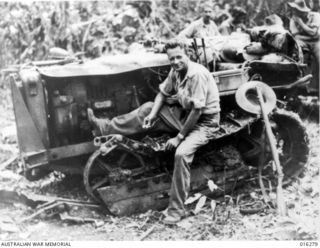 New Guinea. 17 December 1943. Sapper W. R. Middleton of Southport, Qld, working on the track of a tractor blown off by a Japanese land mine. He exploded the mine on a track while hauling a log for ..