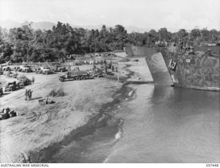 FINSCHHAFEN, NEW GUINEA. 1943-09-22. BEACH SCENE SHOWING FINSCHHAFEN FORCE TRANSPORT WAITING TO BE LOADED INTO LANDING SHIP, TANK (LST)