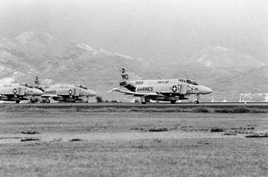 A right side view of three F-4 Phantom II aircraft from Marine Fighter Squadron 212 (VMF-212) preparing for takeoff during an ALPHA STRIKE exercise