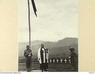 DUMPU, NEW GUINEA. 1944-02-06. VX39632 CHAPLAIN F.J. HARTLEY, (METHODIST) (1) AND SX1476 CHAPLAIN D.L. REDDING, (CHURCH OF ENGLAND) (2) JOINTLY CONDUCTING THE DEDICATION SERVICE AT THE DUMPU WAR ..