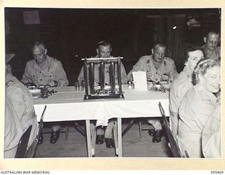 LAE AREA, NEW GUINEA, 1945-08-25. THE PRESIDENT'S TABLE DURING THE VICTORY DINNER HELD IN THE OFFICERS' MESS, 4 ADVANCED ORDNANCE DEPOT, AUSTRALIAN ARMY ORDNANCE CORPS. IDENTIFIED PERSONNEL ARE:- ..