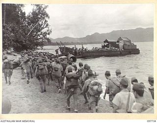KAHILI, BOUGAINVILLE. 1945-10-02. JAPANESE ARMY TROOPS LOADED WITH GEAR MOVE ALONG THE BEACH ONTO AUSTRALIAN LANDING CRAFT FOR TRANSPORT OUT TO THE SHIP NEENA EN ROUTE TO THE CONCENTRATION AREA ON ..