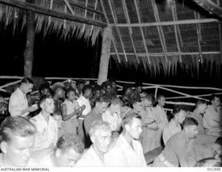 MADANG, NEW GUINEA. 1944-12-25. THE CHOIR OF NATIVE BOYS CHANTING AT THE REAR DURING MIDNIGHT MASS FOR CHRISTMAS AT RAAF MEMORIAL CHAPEL. CELEBRANT WAS FATHER C. VAWDREY OF THE FRANCISCAN ORDER, ..