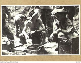 MOUNT PROTHERO AREA, NEW GUINEA. 1944-01-20. NX111543 PRIVATE WHITTY (1) AND QX34529 PRIVATE P.L. MADDEN (2) COOKS OF THE 2/12TH INFANTRY BATTALION PREPARING A HOT MEAL FOR THE TROOPS PRIOR TO THE ..